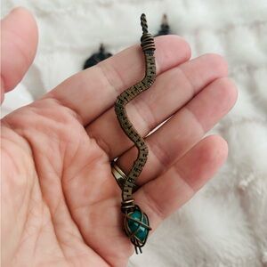 Antiqued copper wire woven snake pendant with emerald head.